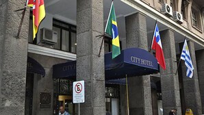 A hotel entrance with multiple flags, a sign indicating no smoking, and a "City Hotel" sign. - City Hotel Porto Alegre (Porto Alegre)