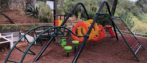 A playground with climbing structures, slides, and a bench.