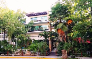 A multi-story building with balconies and a central entrance.