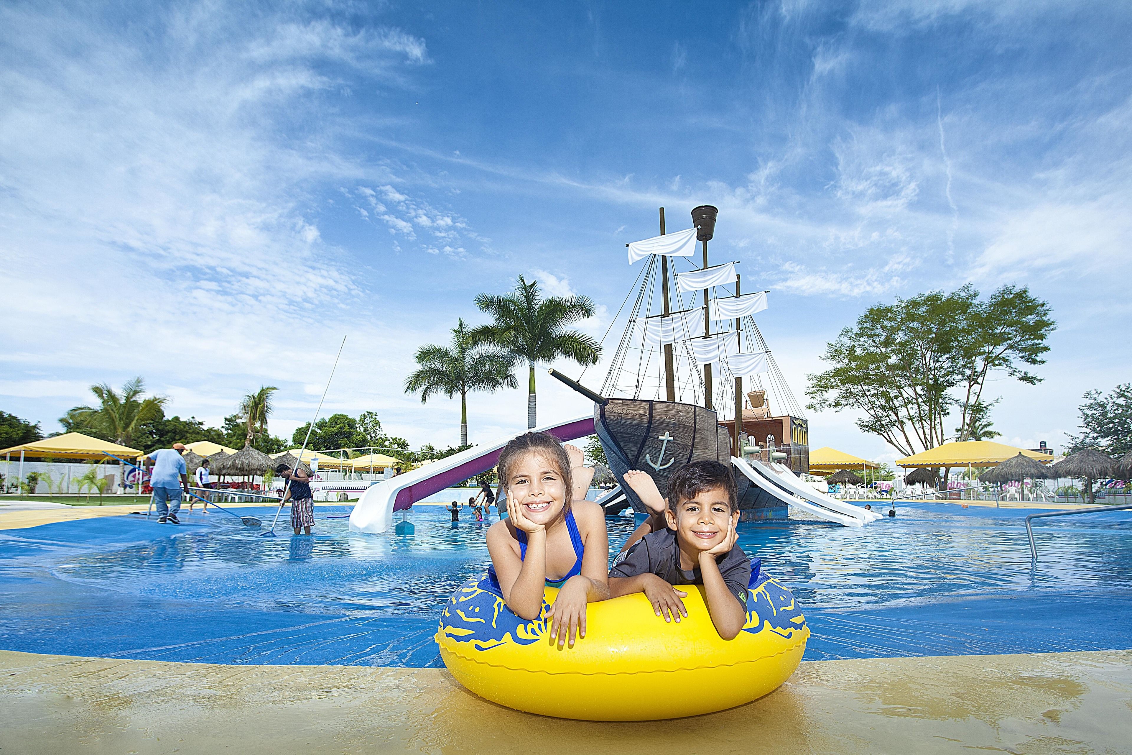 A water park with a ship-themed slide and palm trees.