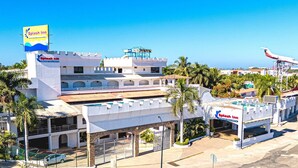 A hotel with multiple floors, a prominent sign, and a view of the ocean. - Hotel Splash Inn Nuevo Vallarta (Nuevo Nayarit)
