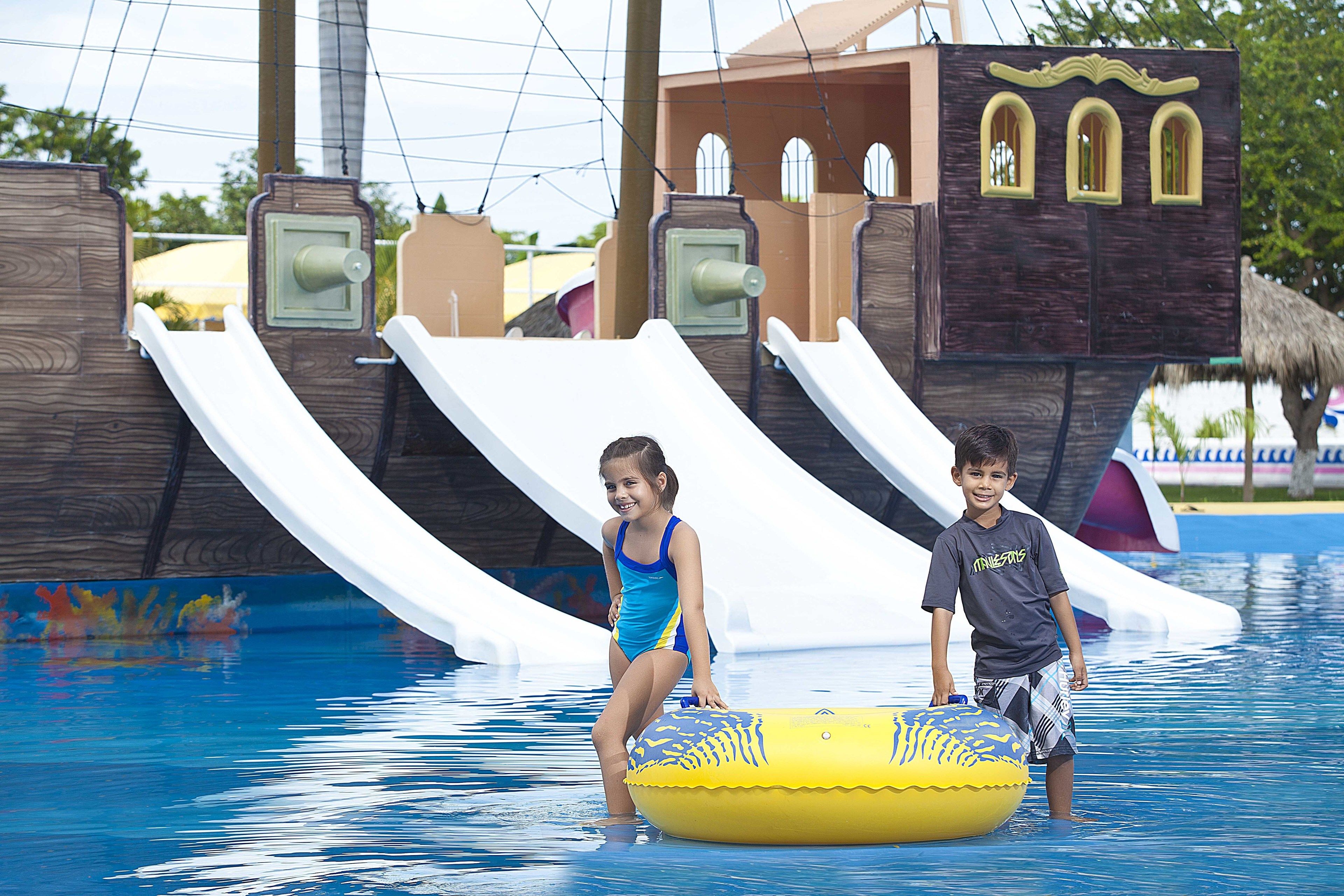 Un parc aquatique avec des toboggans et un espace de jeux sur le thème des pirates.
