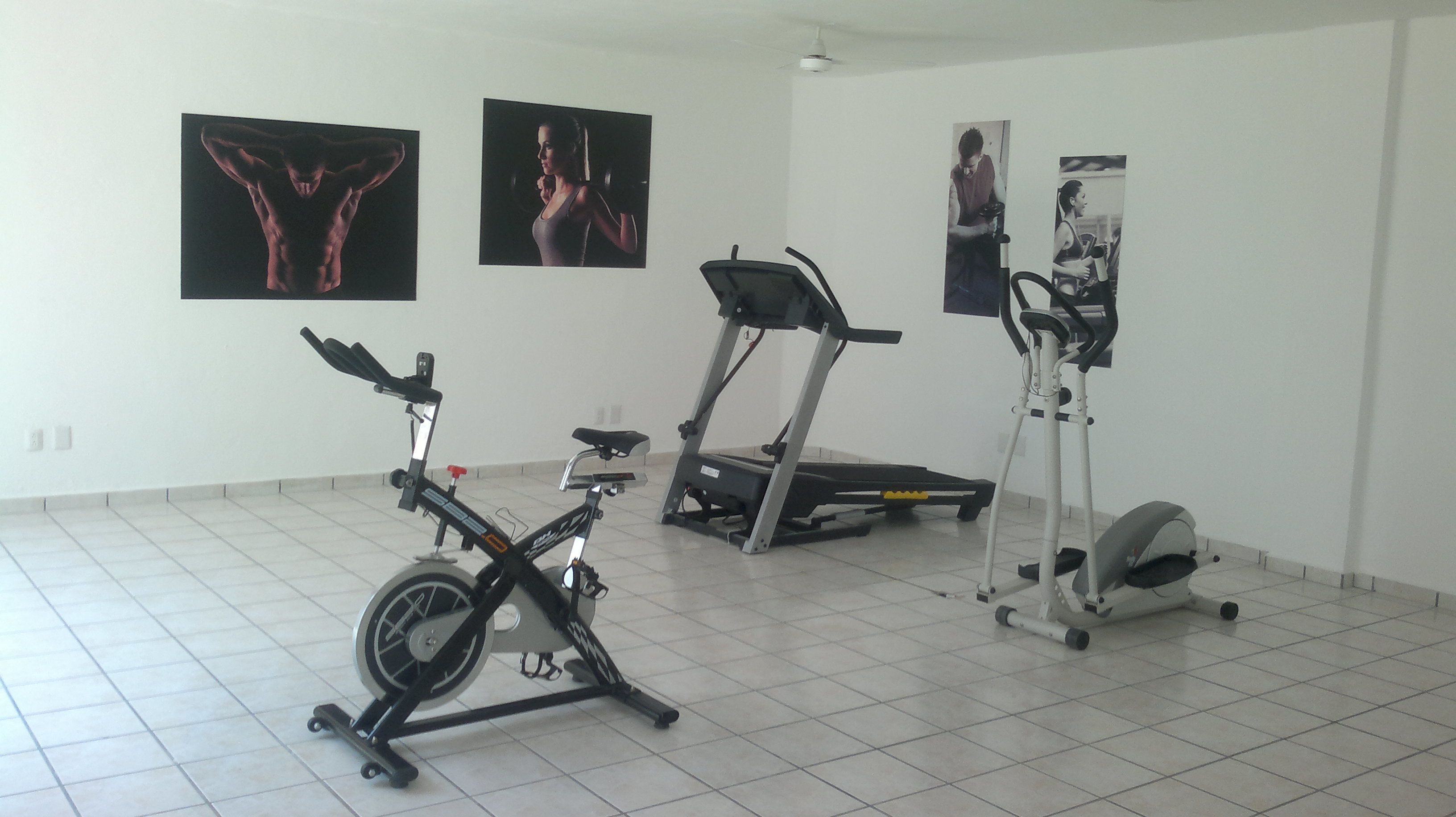 Ein Fitnessraum mit Ergometer, Crosstrainer und Laufband.