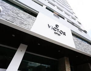 A hotel sign with the name "VICTOR HOTEL" prominently displayed.