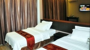A hotel room with two beds, a large mirror, and a television on the wall. - Goldenhill Hotel (Kota Kinabalu)
