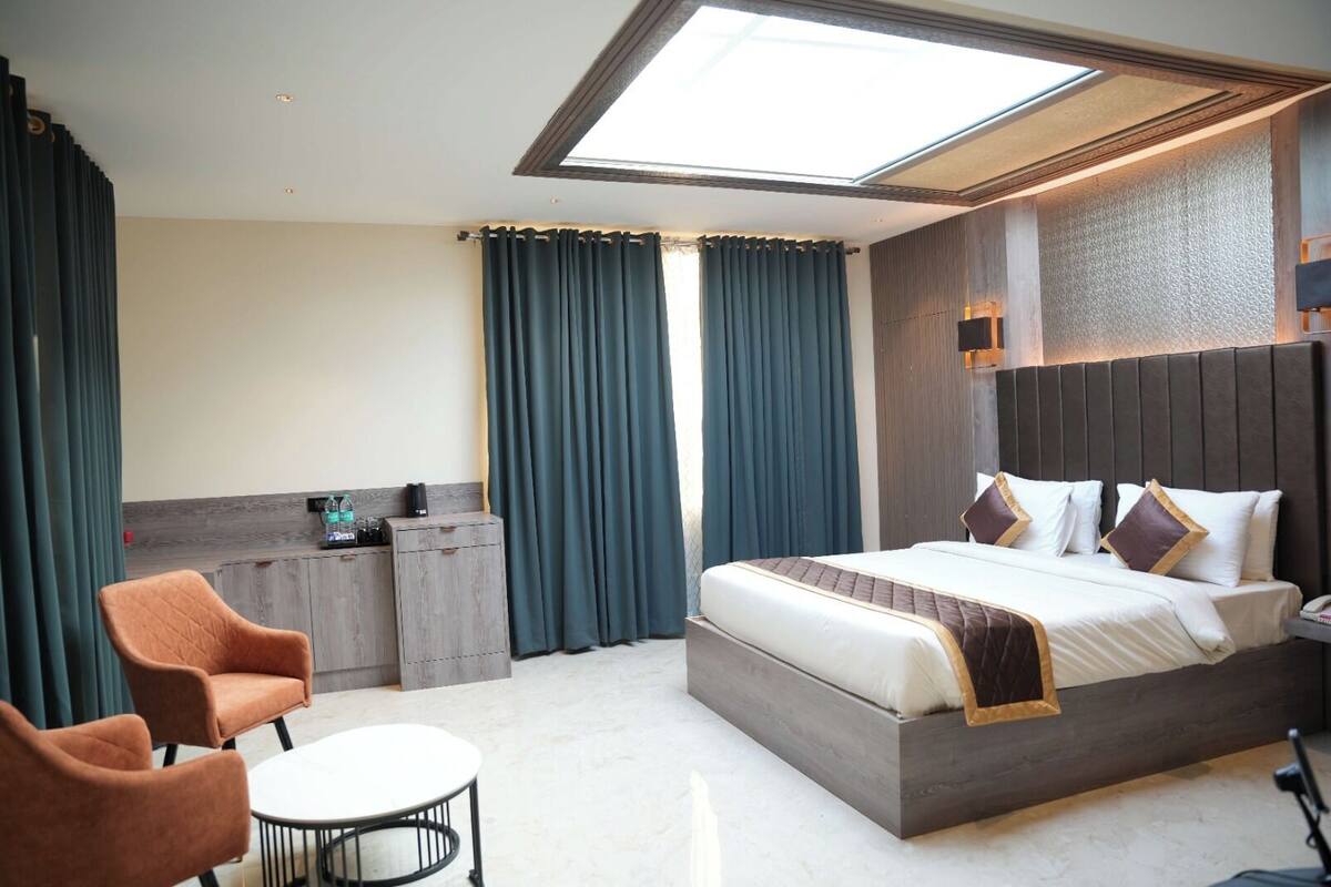 Una habitación de hotel moderna con una cama grande, un escritorio, una silla y una mesita.