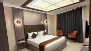 Une chambre moderne avec une lucarne, un grand lit, deux chaises et une petite table.