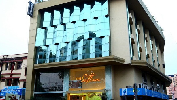 Un bâtiment moderne doté d’une façade en verre et d’une enseigne indiquant « The Saffron Boutique Hotel ».