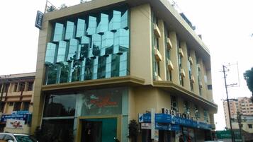 Un hotel con fachada moderna, grandes ventanales y un llamativo cartel que dice 'The Cactus Boutique Hotel'.