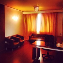 Uma sala de estar com uma mesa de centro de vidro, dois sofás e um lustre.