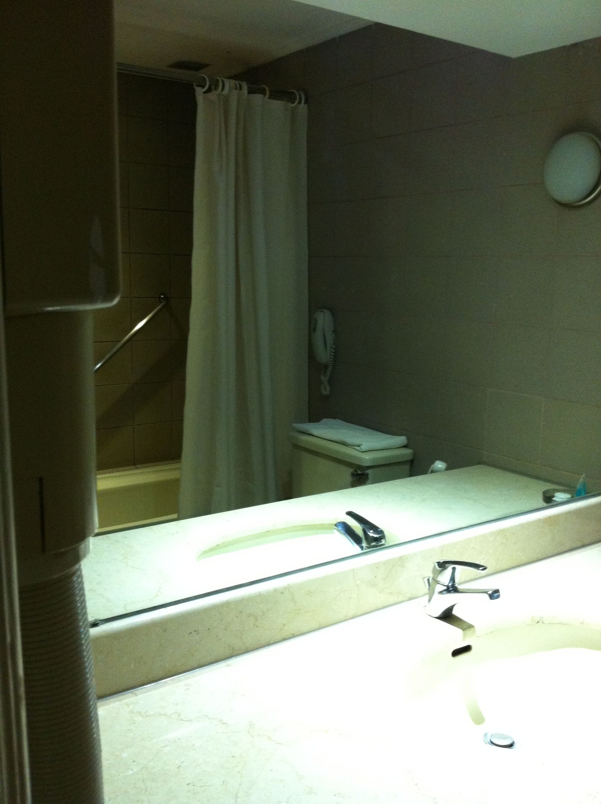 A bathroom with a shower, toilet, and sink.