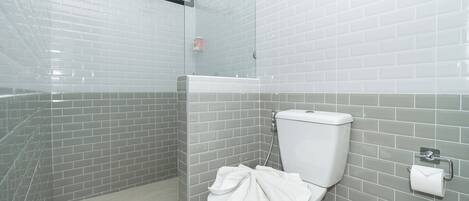 Ein Badezimmer mit Toilette, Duschkabine und Glasabtrennung.