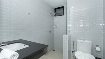 A bathroom with a bathtub, toilet, and shower.
