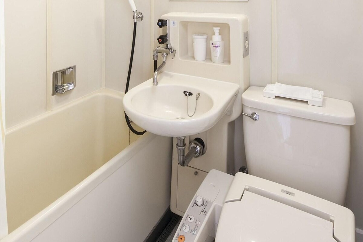 A bathroom with a bathtub, a sink, a toilet, and a mirror.
