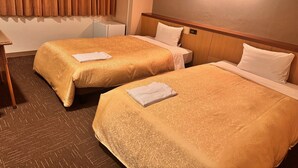 A hotel room with two beds, a desk, and a wall-mounted light. - Sunsky Hotel (Kitakyushu)