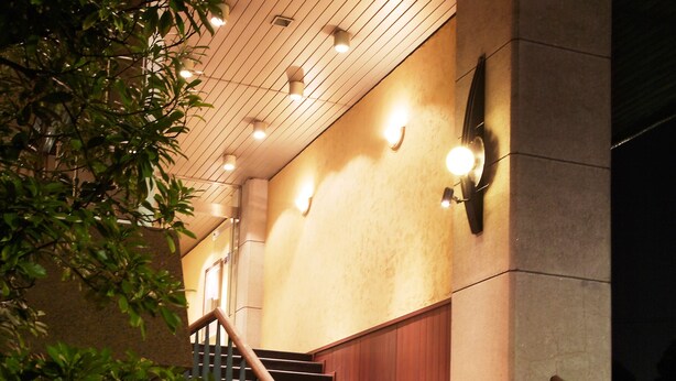 A staircase with wooden railings and stone steps leading to a building entrance. - Sunsky Hotel (Kitakyushu)