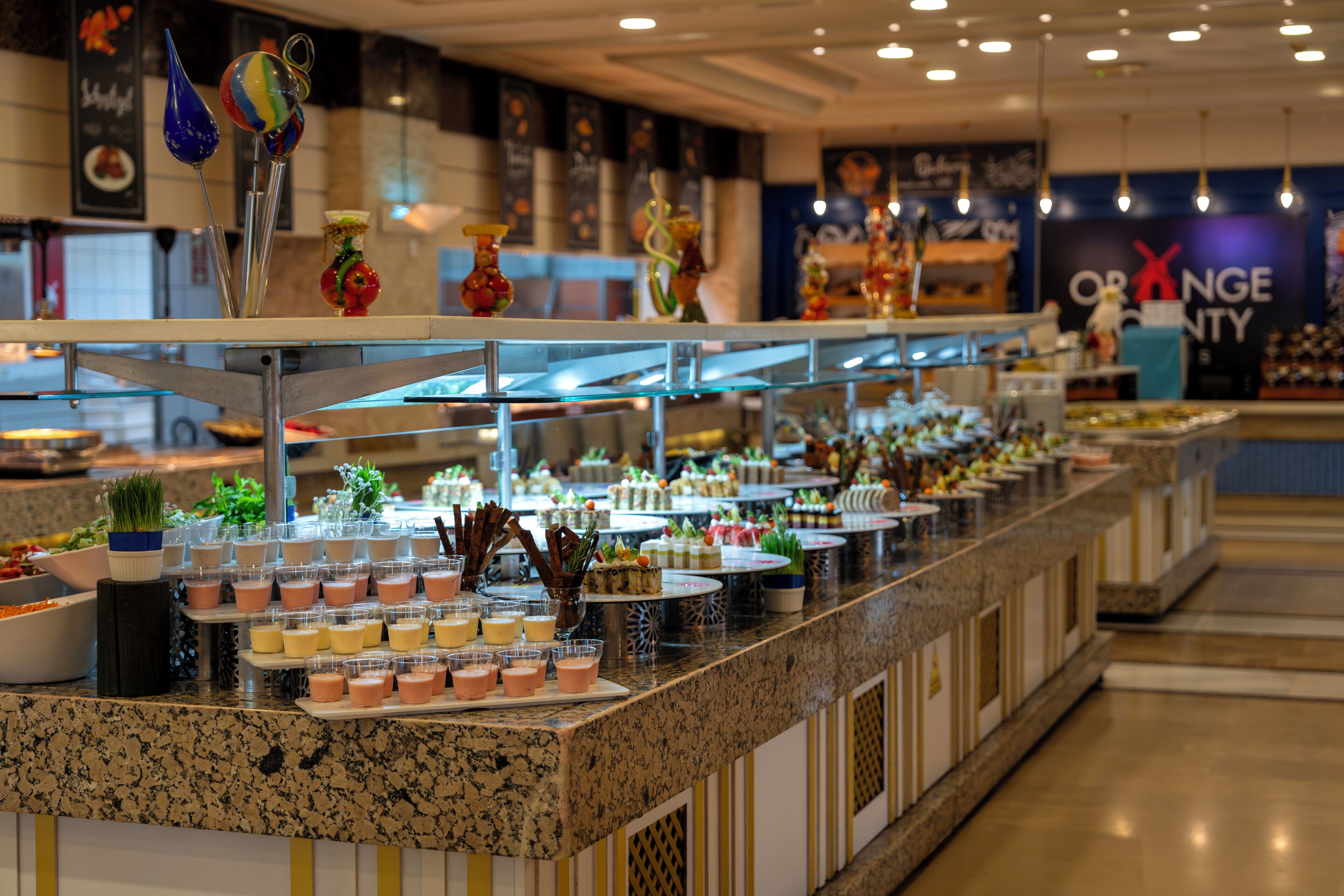 A buffet area with various food items and decorative glassware.