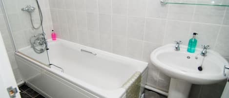 A bathroom with a bathtub, a sink, and a toilet.