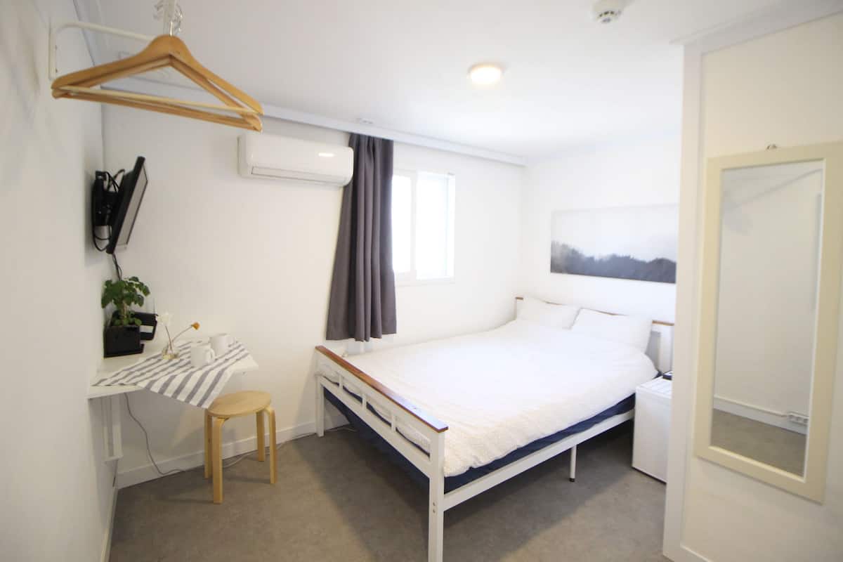 Une chambre à coucher avec un lit, une table de chevet et un bureau avec une chaise.