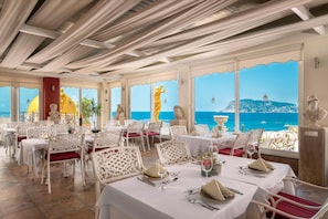 A restaurant with white table settings, red cushions, and a view of the sea. - Antique Roman Palace Museum Hotel - Adults Only Ultra All Inclusive (Alanya)