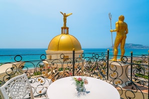 A seaside view with a golden statue, a golden dome, and a table with a vase of flowers. - Antique Roman Palace Museum Hotel - Adults Only Ultra All Inclusive (Alanya)