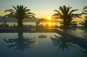 Una piscina al aire libre de temporada, sombrillas