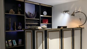 A modern kitchen with a central island, built-in shelves, and a clock on the wall. - Hotel Toskana (Wiesbaden)