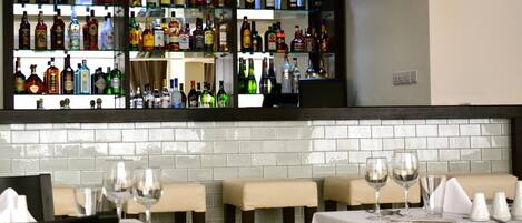 A bar area with multiple shelves of liquor bottles.