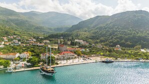 A coastal town with a marina, buildings with red roofs, and a prominent church. - Vila Riva Apartments (Dubrovacko Primorje)