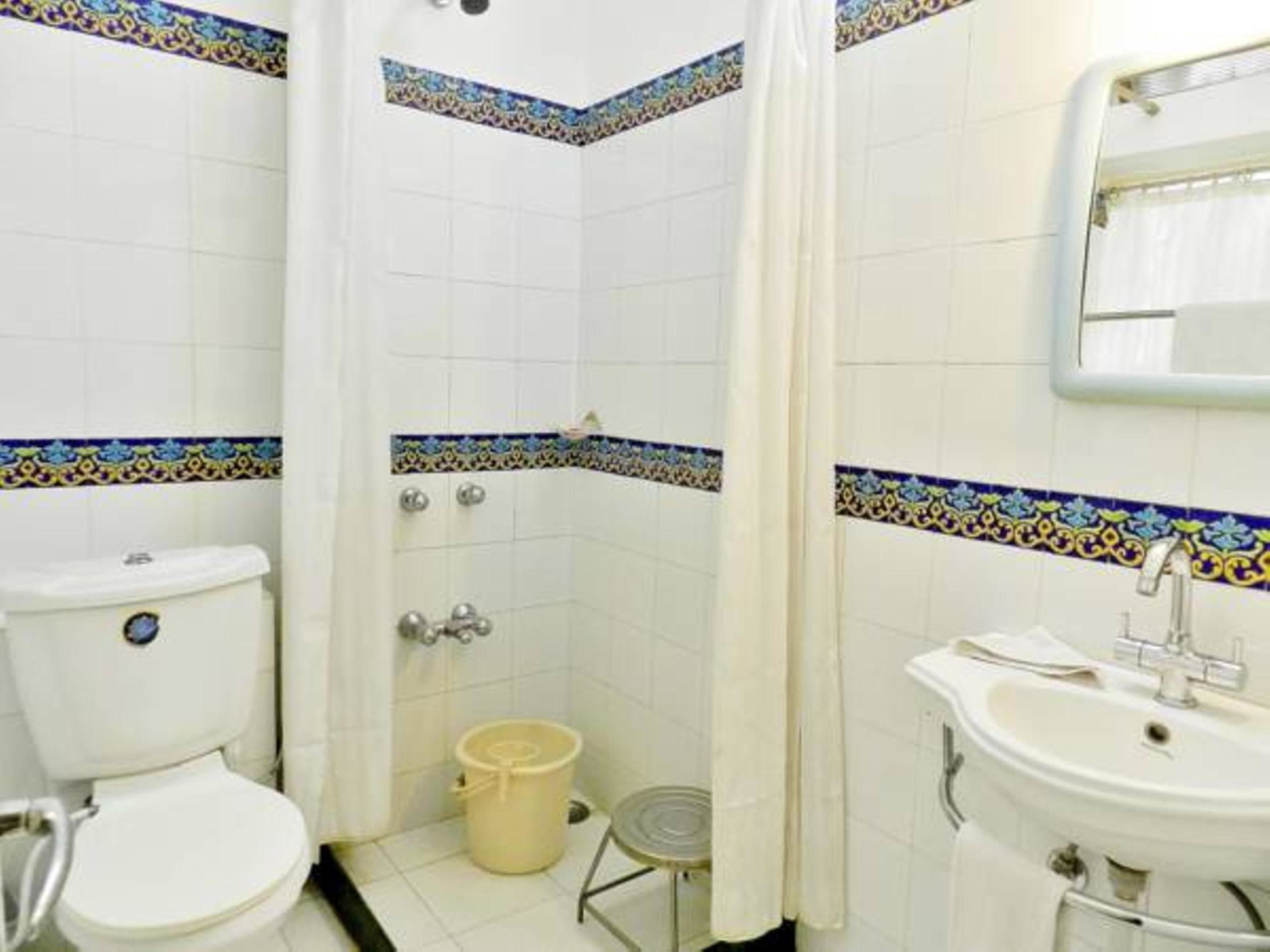 Un baño con inodoro, lavabo y zona de ducha.