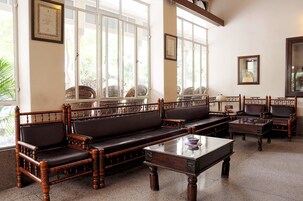 Quarto tradicional com um conjunto de sofás, uma mesa de centro e um espelho.