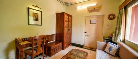 Un salón tradicional con una mesa de madera, sillas, un sofá y un aparador.