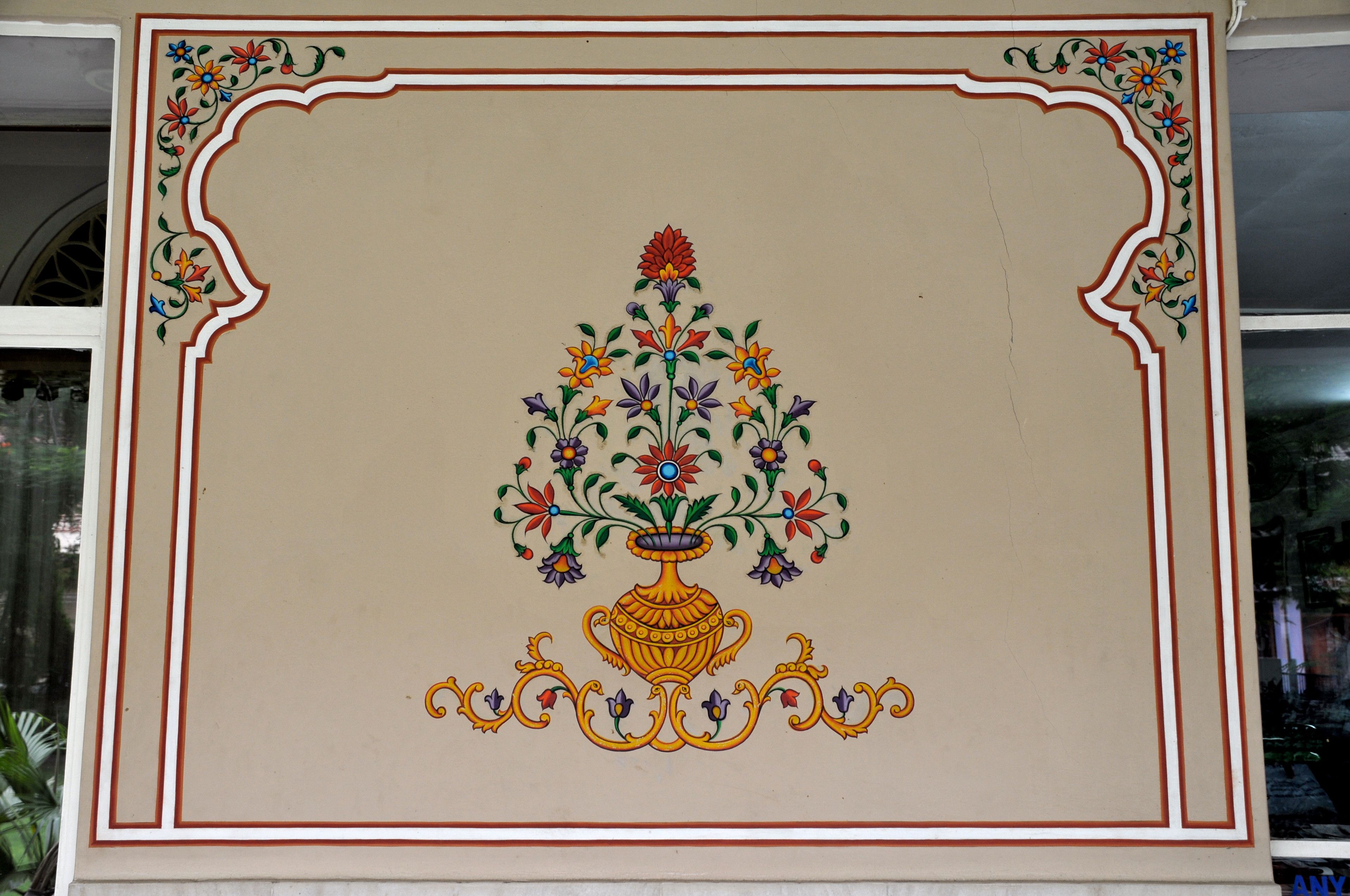 Una pared decorativa con un estampado floral y un jarrón.