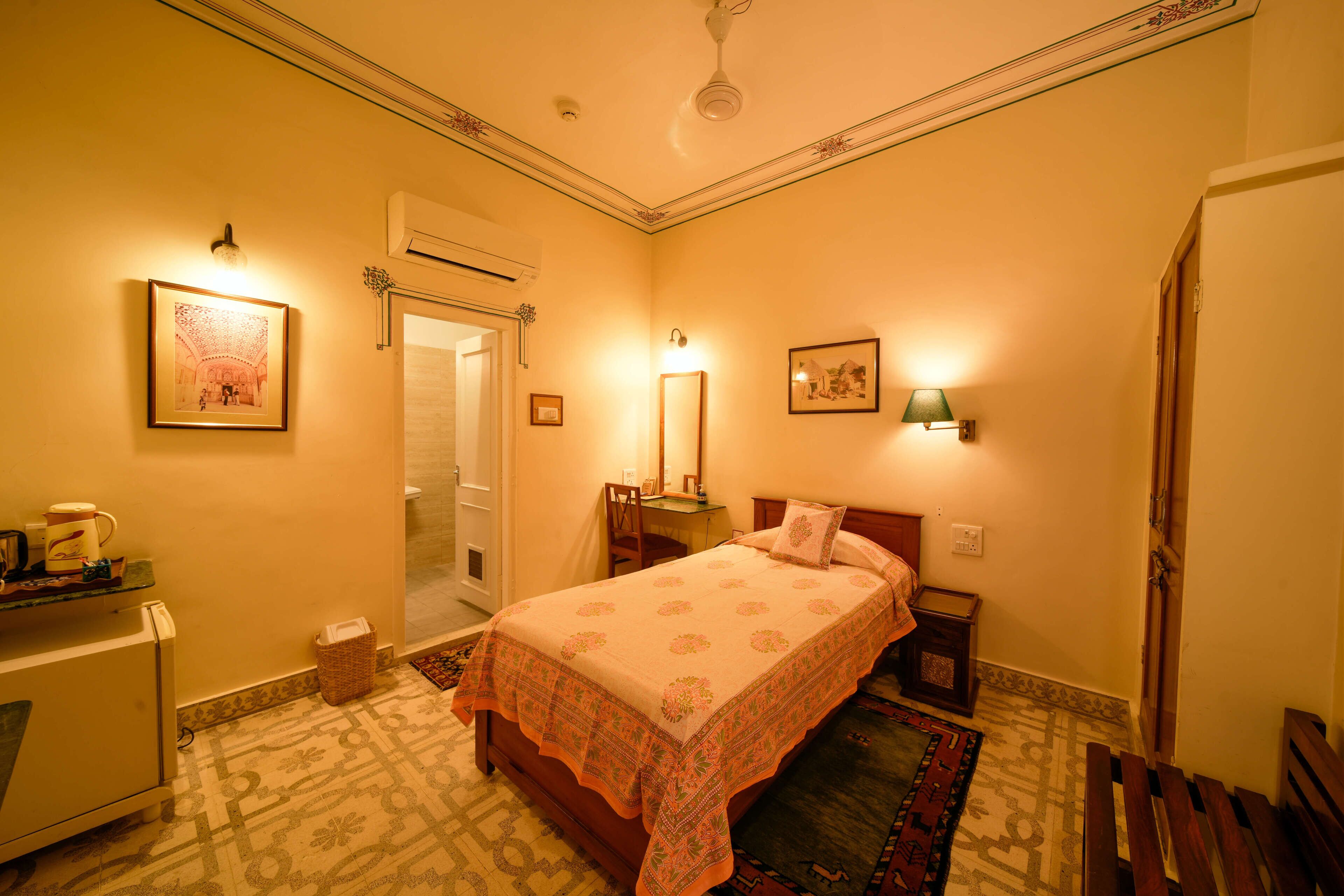 A bedroom with a bed, bedside tables, a desk, and a chair.