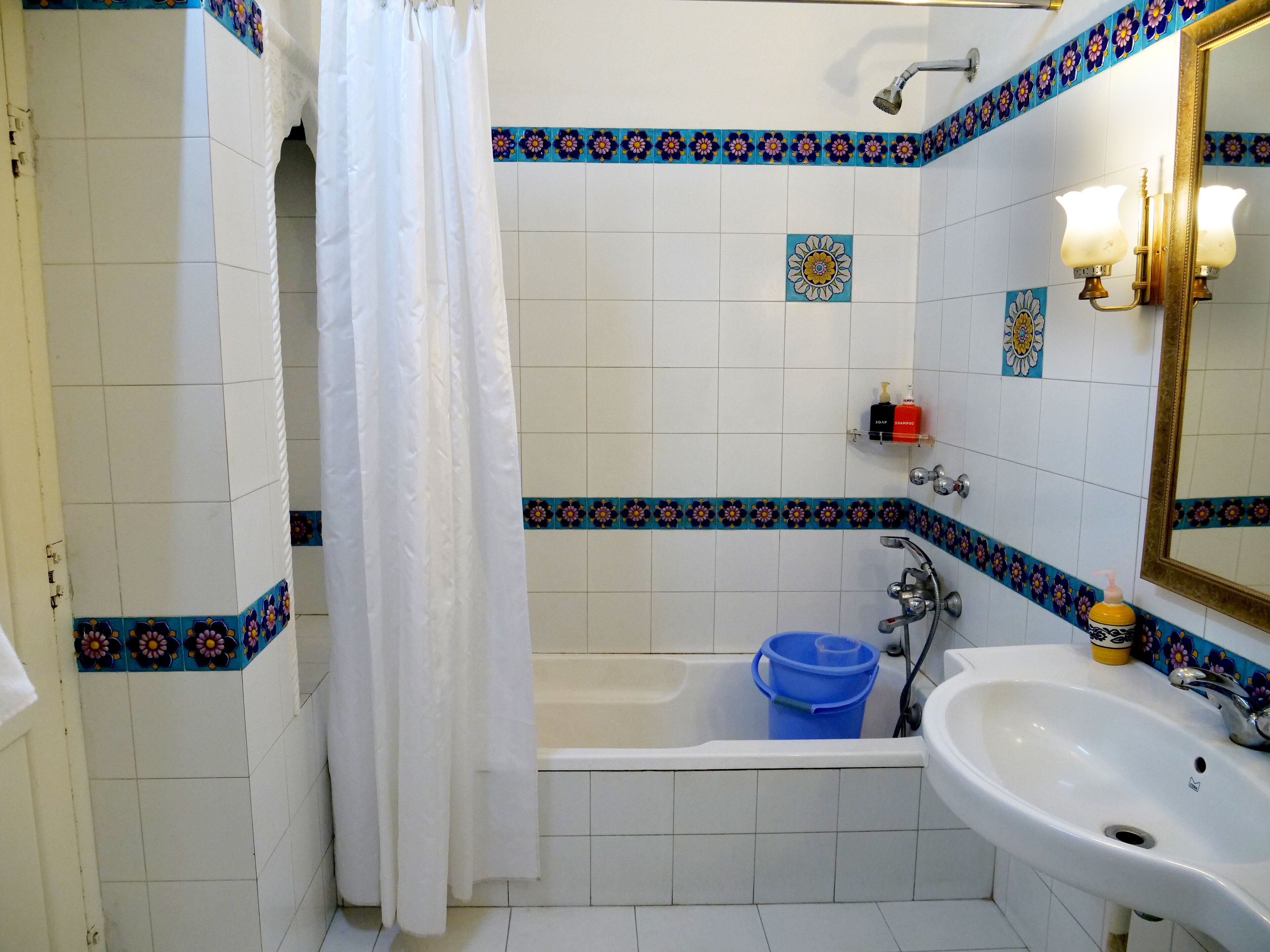 A bathroom with a bathtub, a sink, and a shower curtain.