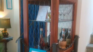 A display case with a blue sign, containing bottles and glasses, possibly for sale or display. - Soggiorno Sogna Firenze (Florence)
