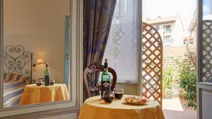 A room with a bed, a table with a bottle and glasses, and a view of the outside. - Soggiorno Sogna Firenze (Florence)