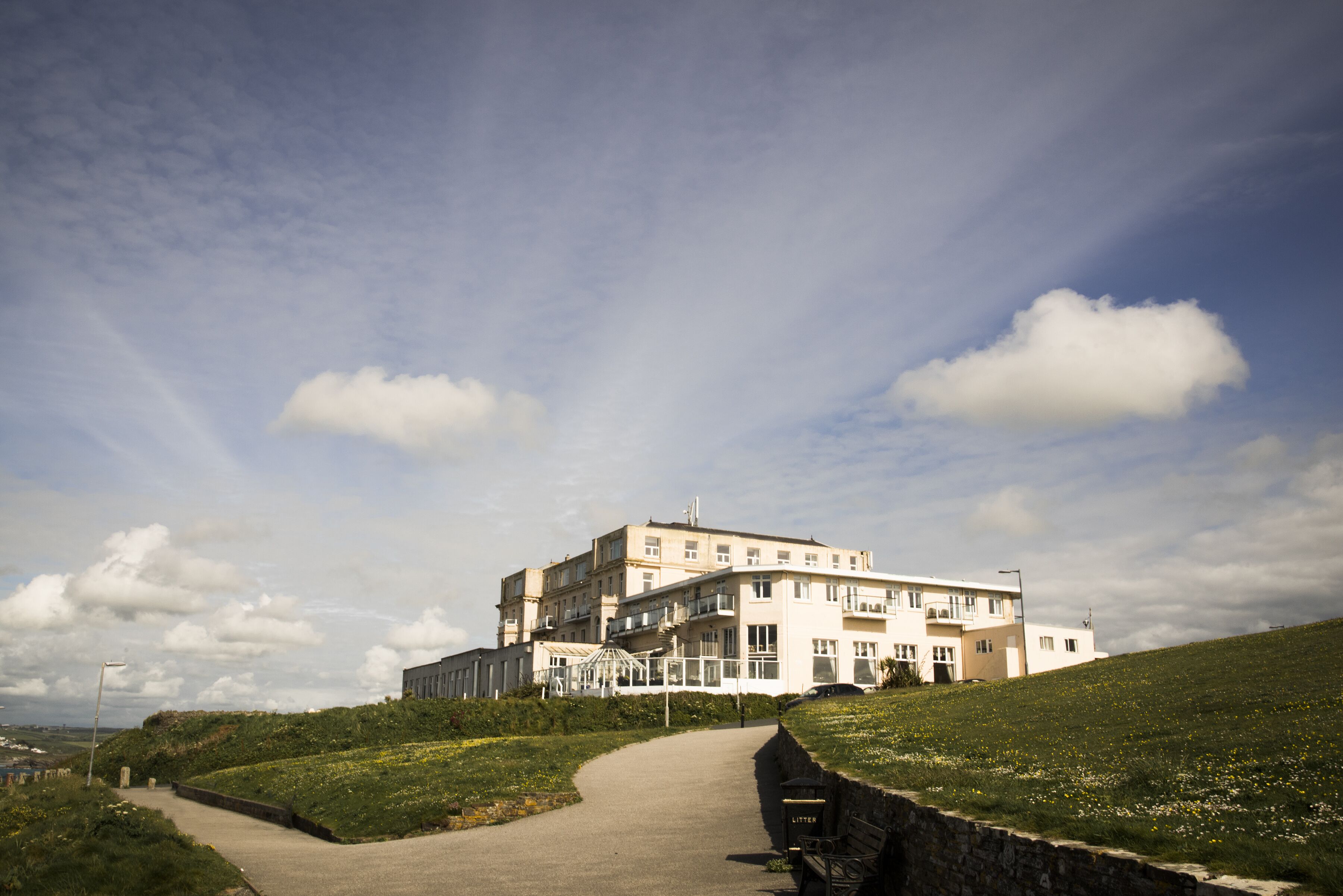 A large, multi-story building with a pathway leading to its entrance.