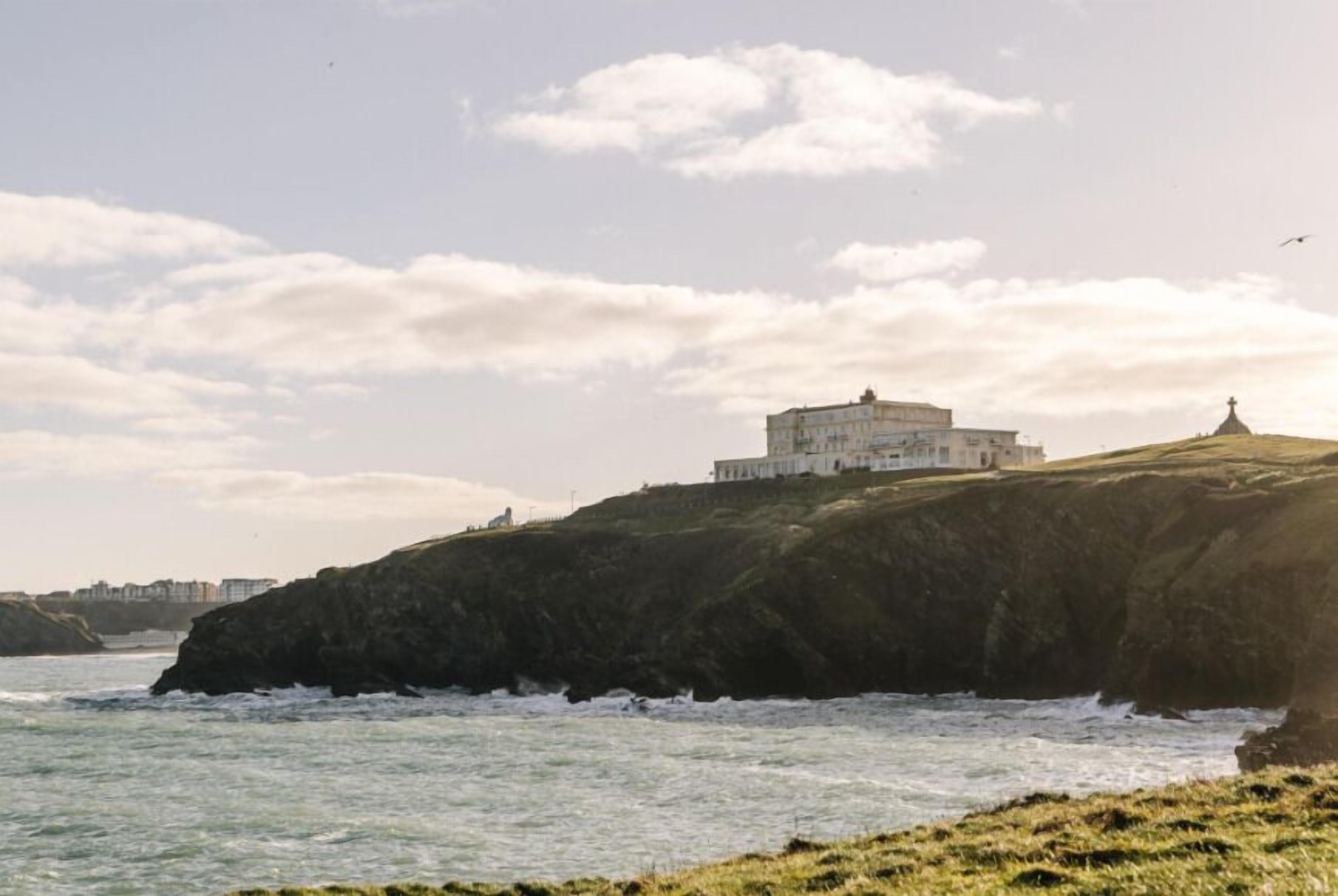 Un edificio costiero con un faro su una scogliera che si affaccia sul mare.