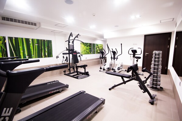 A gym with treadmills, elliptical machines, and weight equipment.
