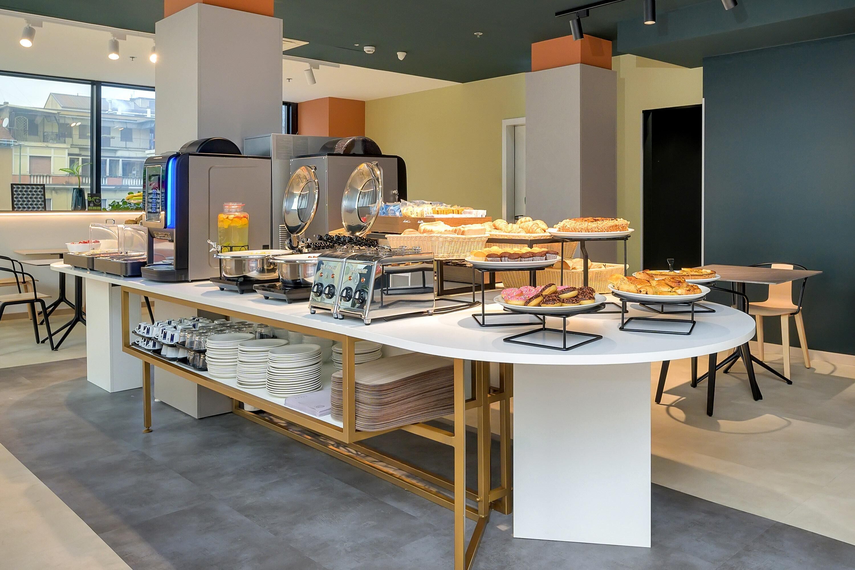Ein reichhaltiges Buffet mit verschiedenen Speisen, einer Kaffeemaschine und einem Saftspender.