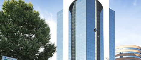 Un edificio moderno de hotel con fachada de vidrio curva y un letrero que indica que es un hotel B&B.
