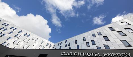 Clarion Hotel Energy, en bygning med moderne arkitektur, karakteriseret ved et markant skilt og store vinduer.
