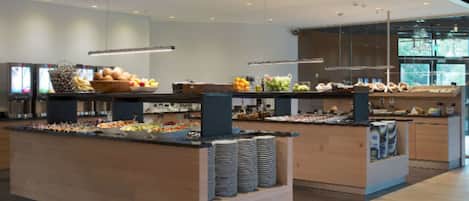 A modern buffet setup with various food items and beverages.