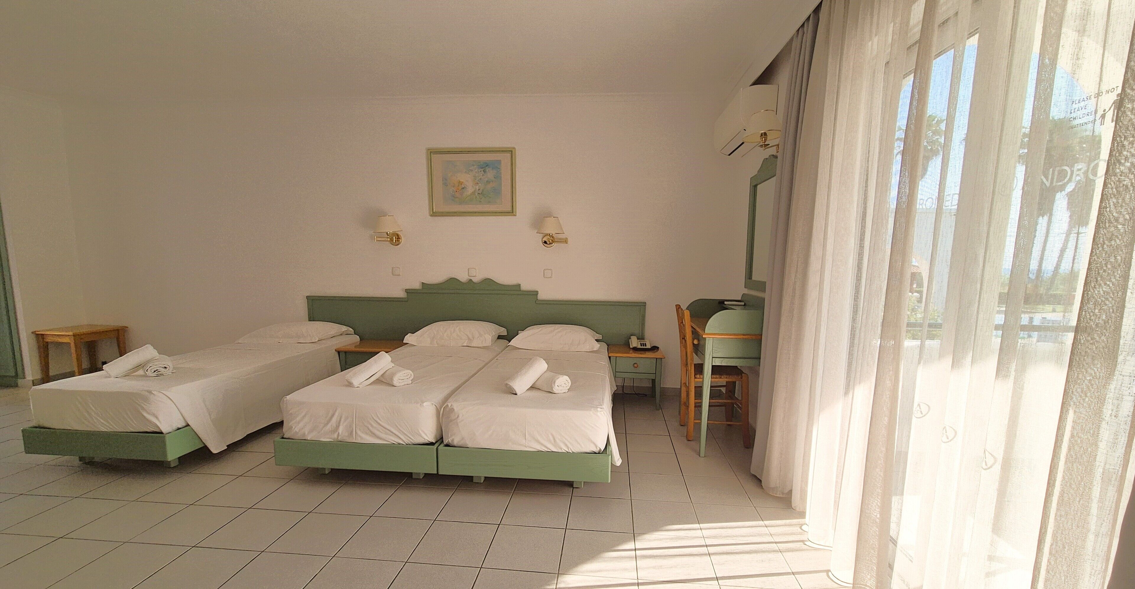 Een hotelkamer met twee bedden, een bureau en een stoel.