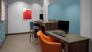A modern office space with a desk, two chairs, a computer, and a monitor. - Holiday Inn Express & Suites Midland South I-20 by IHG (Midland)