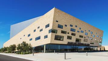 Un bâtiment moderne doté d’un toit plat, de nombreuses fenêtres et surplombant un ciel dégagé.