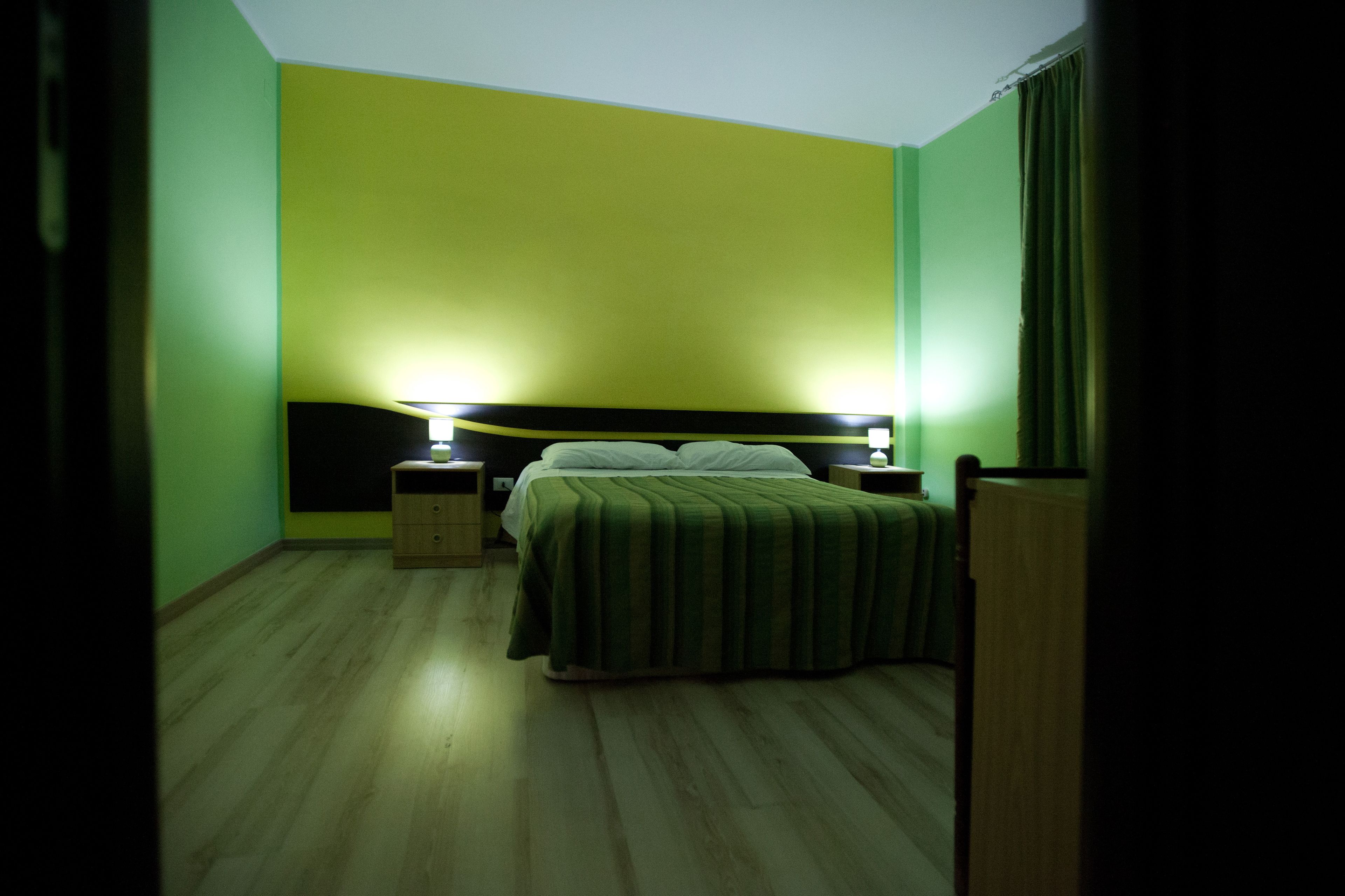 A room with a bed, two bedside tables, and a nightstand.