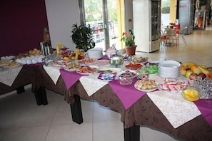 A buffet table with various food items and a Coca-Cola refrigerator in the background. - Hotel Cliché (San Lucido)