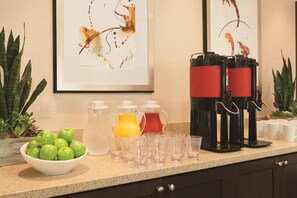 A kitchen counter with a bowl of green apples, a pitcher of orange juice, and a coffee maker. - Hyatt Place at Anaheim Resort/Convention Center (Anaheim)
